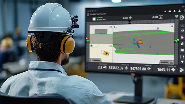 Site Foreman interacting with the construction site via computer in jobsite office