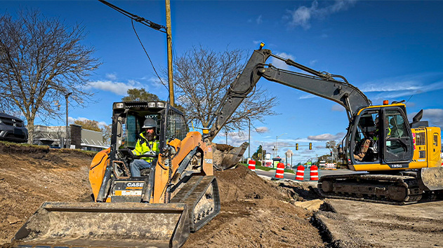 Skid steer loader and excavator working on site using Trimble machine guidance