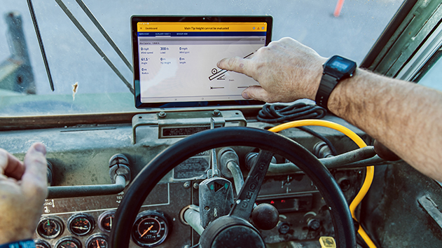 Man in a lifting machine cab using trimble lifting software