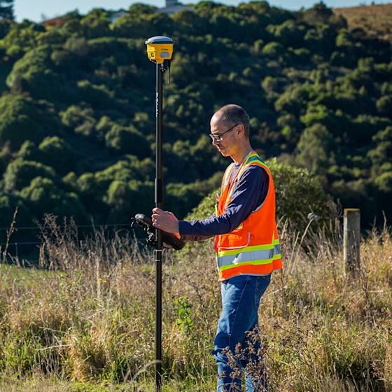 Surveyor using Trimble R780 GNSS system in the field
