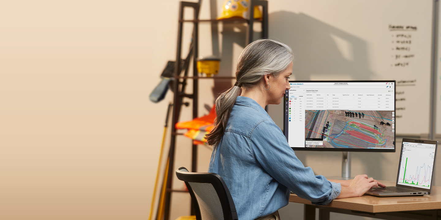 Worker in a construction office using WorksOS software for real-time jobsite visibility