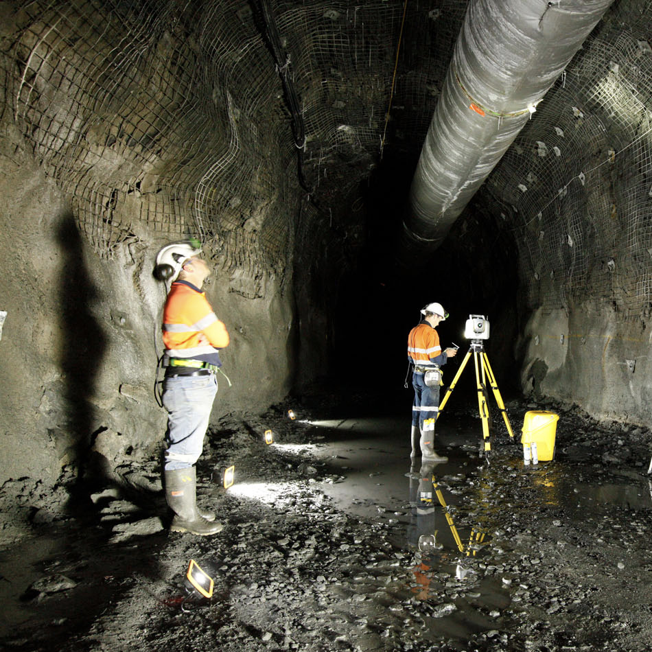 两名身着反光背心的作业人员使用架设于三角架上的 Trimble SX12 全站扫描仪