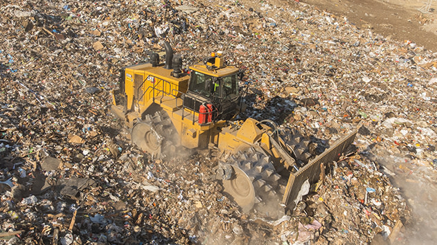 Landfill compactor with Trimble Earthworks compacts waste and debris on landfill