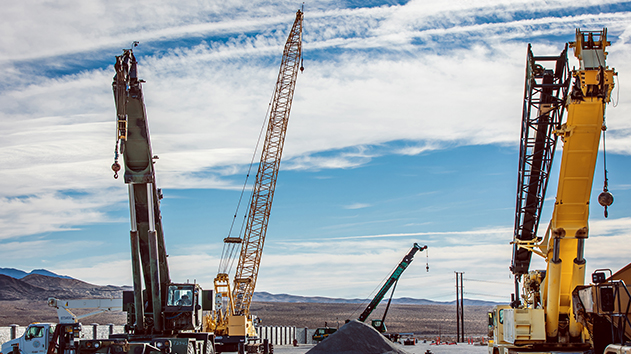Three lifting cranes on a construction site