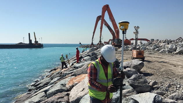 Surveyor using a Trimble R780 antenna in a marine breakwater construction build