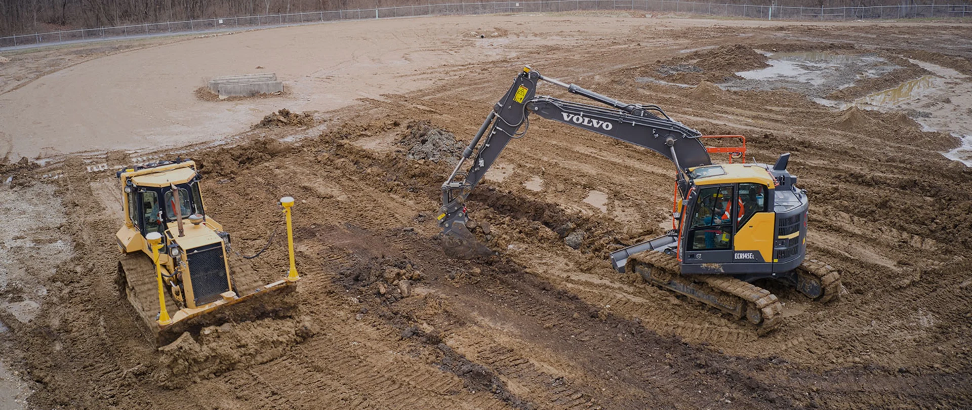 Large excavator and bulldozer managing grade control in a gravel pit