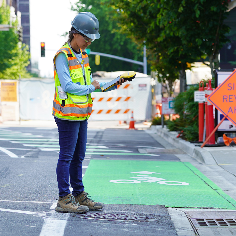 Eine Frau erfasst auf einer Straße Anlagedaten.