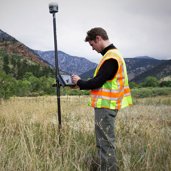 Surveyor using Trimble R12i GNSS system and TSC7 tablet in the field