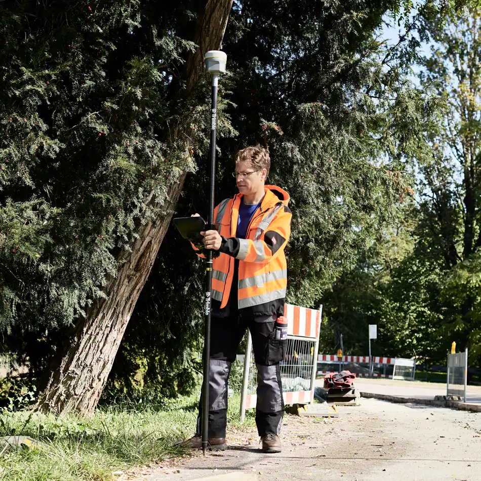 Surveyor in high-visibility vest using R12i GNSS system
