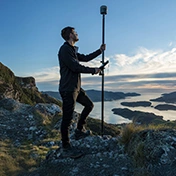Land surveyor on a rugged hill using the Trimble R12i GNSS receiver with the Centerpoint RTX correction service