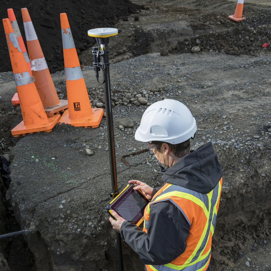 Vermessungsingenieur in Warnweste verwendet Trimble Catalyst mit DA2-Empfänger