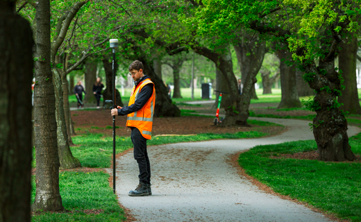 Vermessungsingenieur in einem Stadtpark mit einem GNSS-Rover