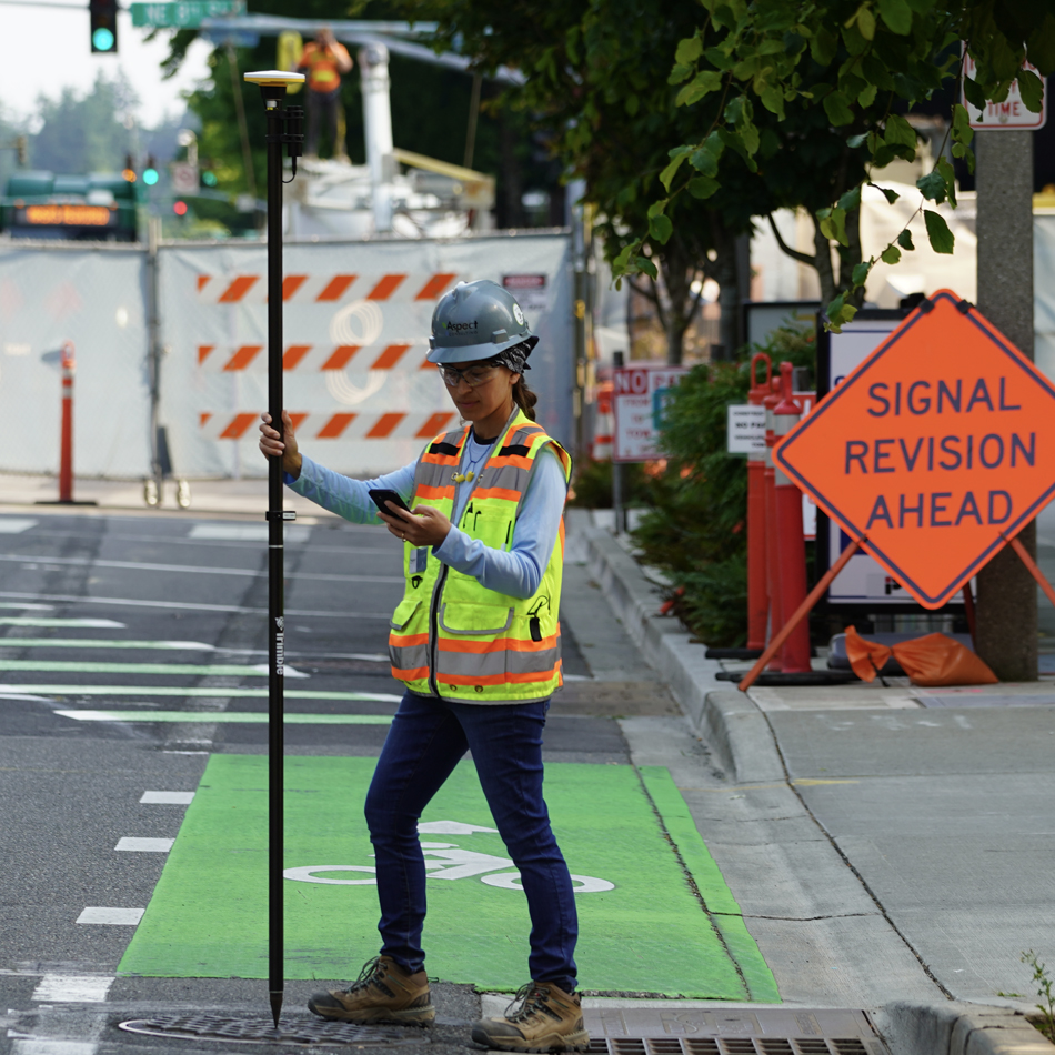 Surveyor in high-visibility vest using Trimble Catalyst with DA2 receiver