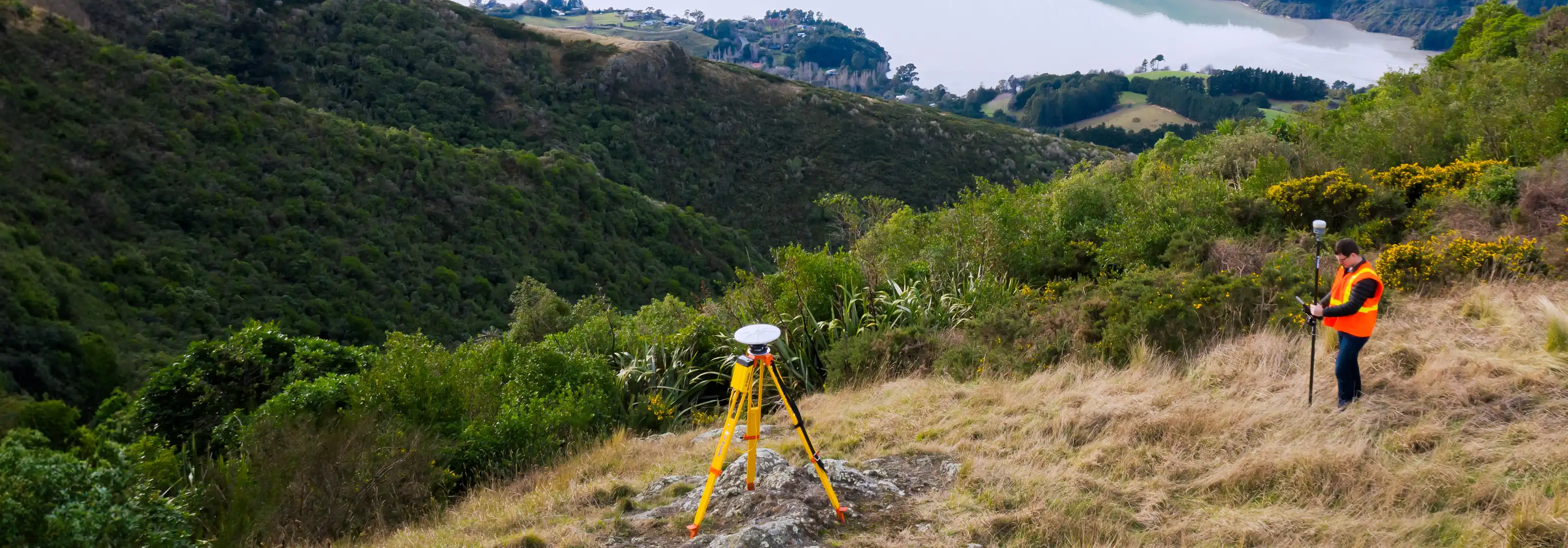 Un professionnel des levés utilise les solutions géospatiales Trimble pour effectuer un travail à flanc de colline.