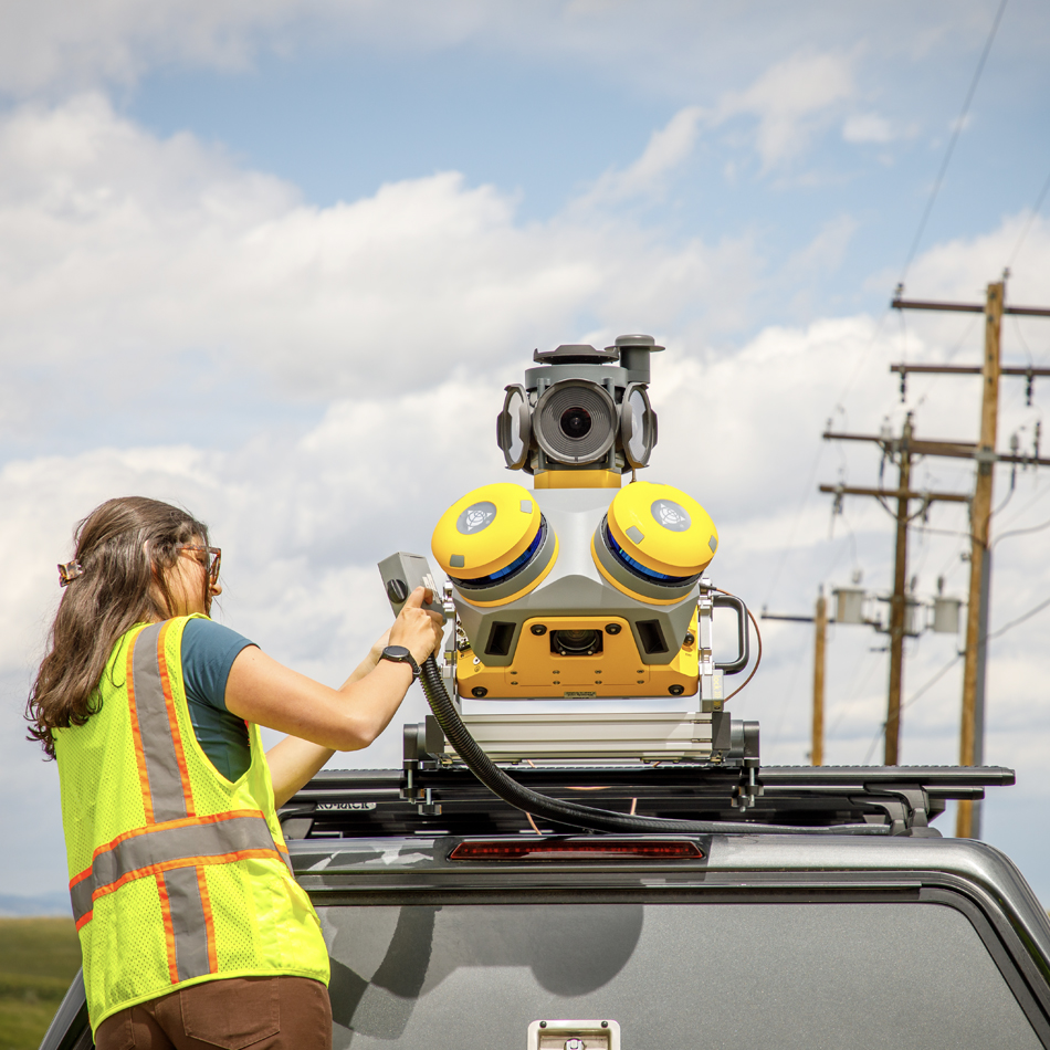 Géomètre en gilet haute visibilité installant le système de cartographie mobile Trimble MX60 sur un véhicule