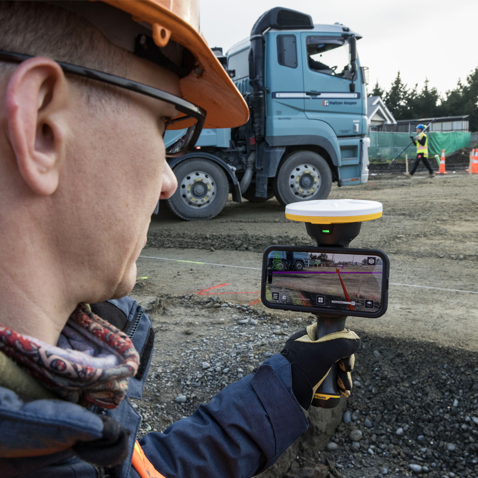 Trabajador de la construcción con casco utilizando Trimble SiteVision en una obra