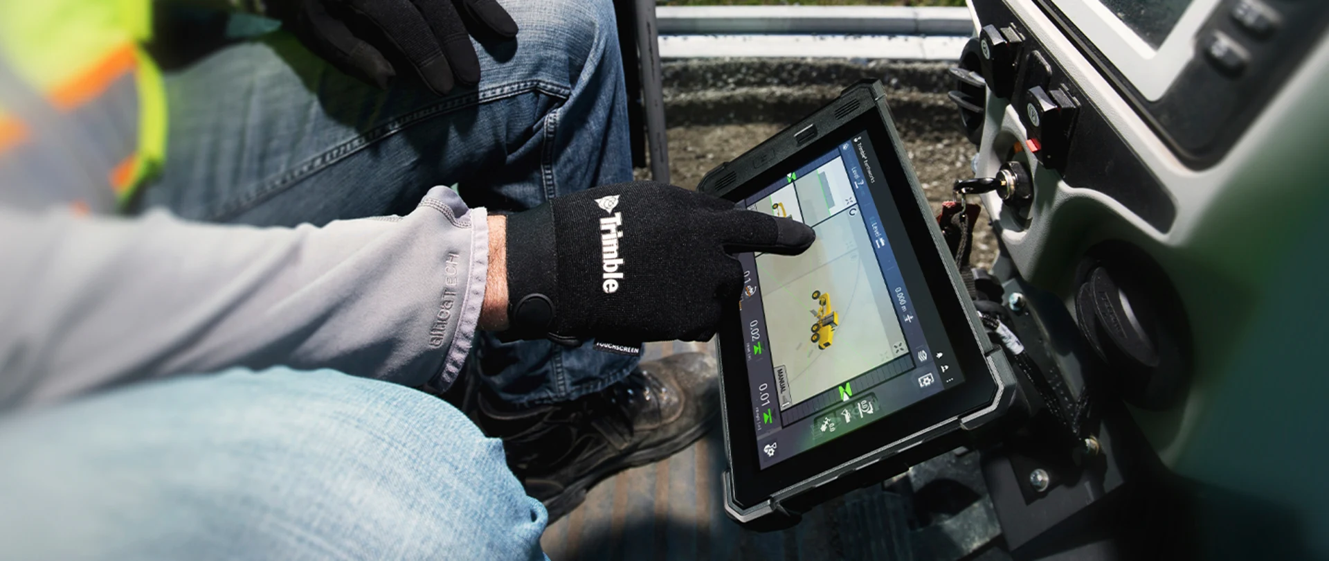 Construction worker in motor grader using Trimble Earthworks in the cab