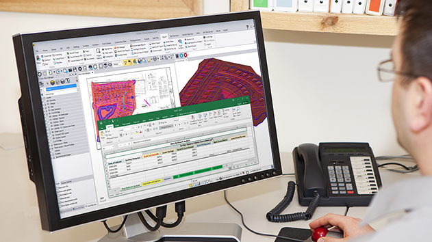 Desktop monitor in an office displaying Trimble Business Center software calculating earthwork, material and cost data