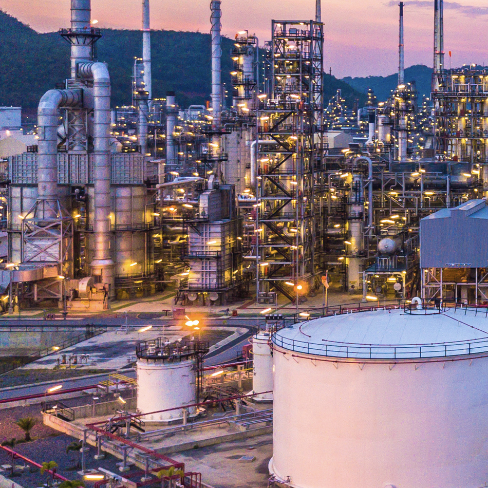 A large oil refinery featuring numerous tanks and interconnected pipes