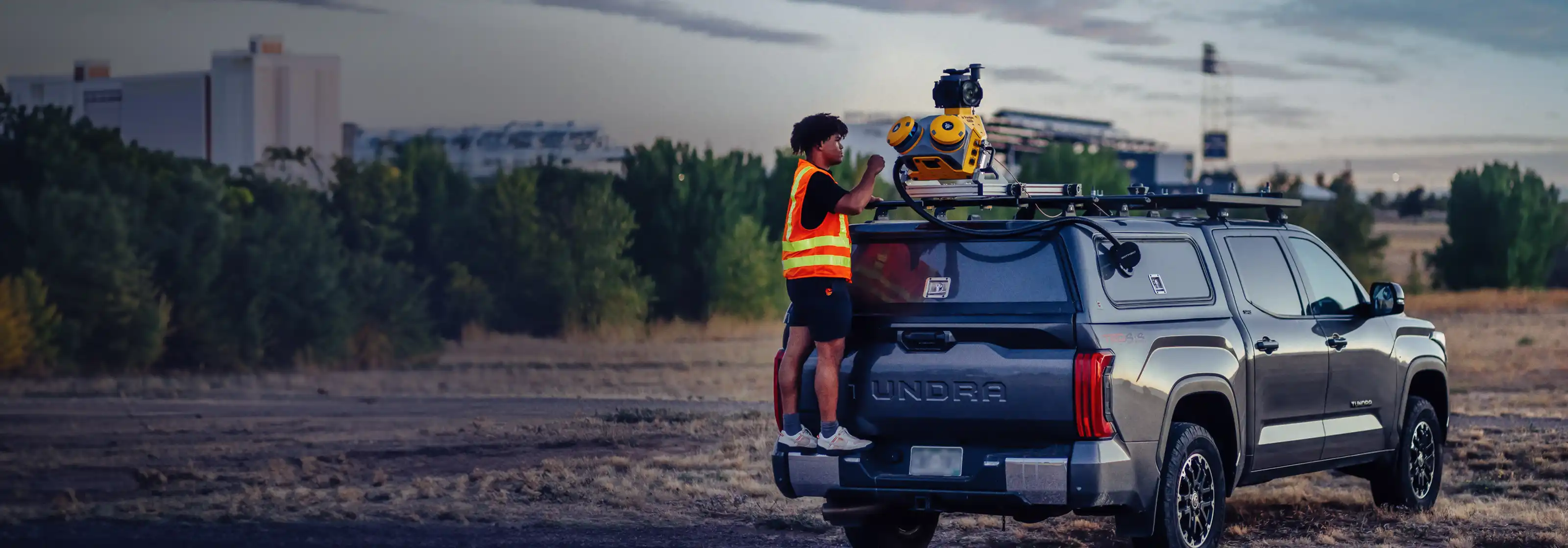 Man on the back of a truck adjusting an MX60 mobile mapping system on the roof of the truck