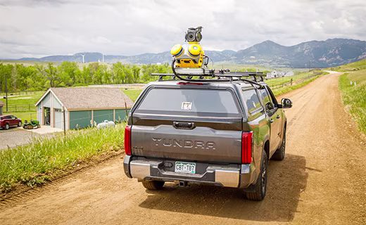 Trimble MX60 mobile mapping system mounted on a moving car's roof