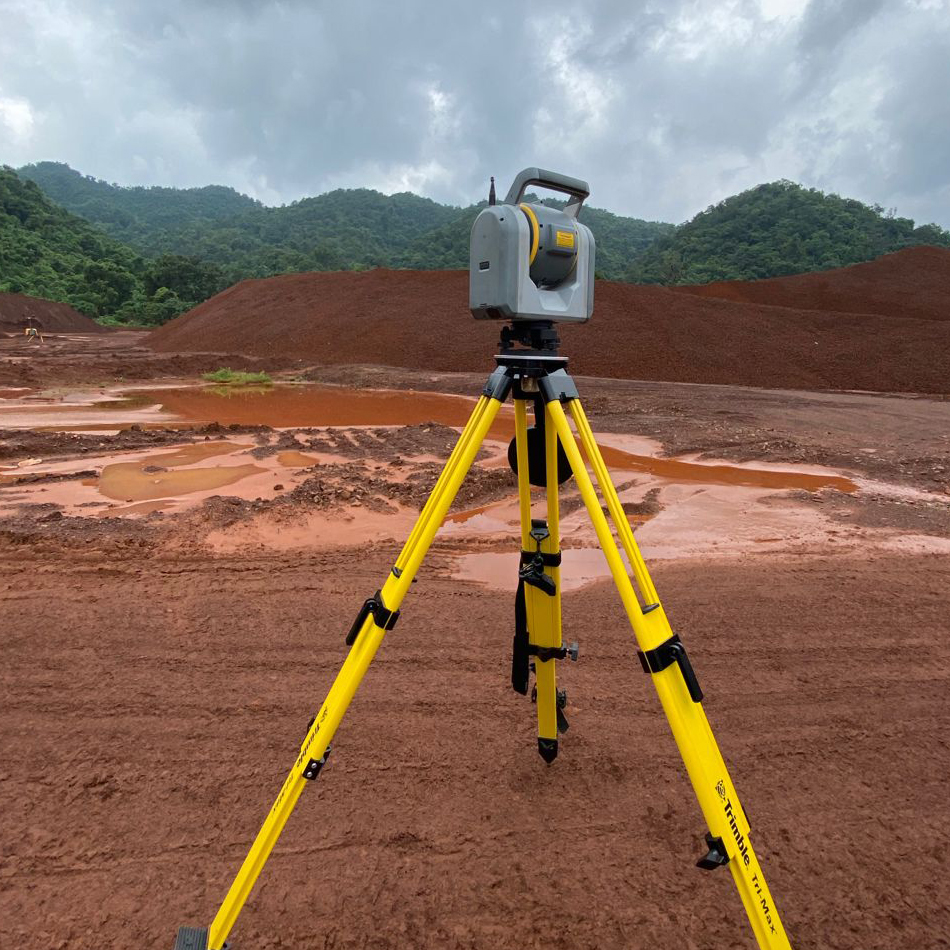 Trimble SX12 total station and scanner set up on a tripod near a mining site