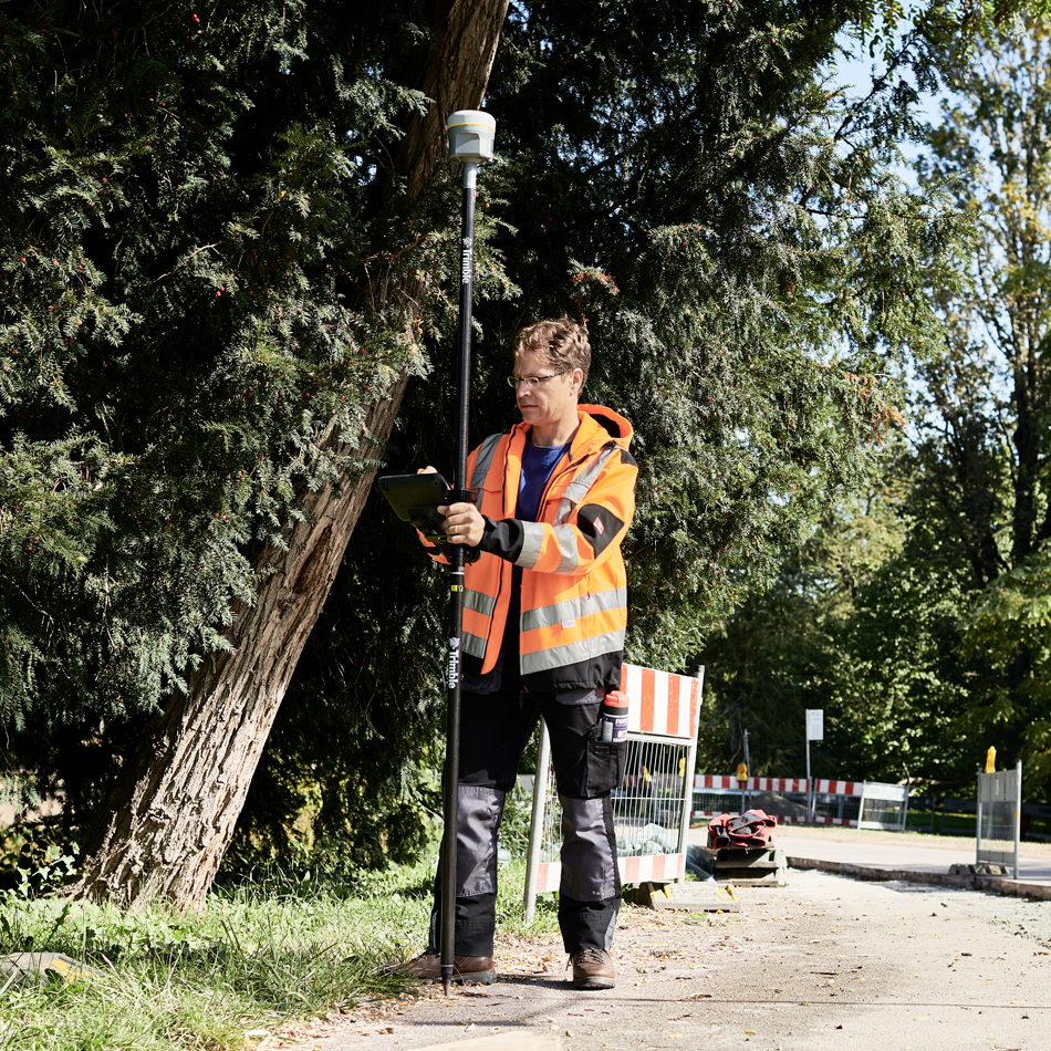 Vermessungsfachleute in Warnweste verwenden das R12i-GNSS-System