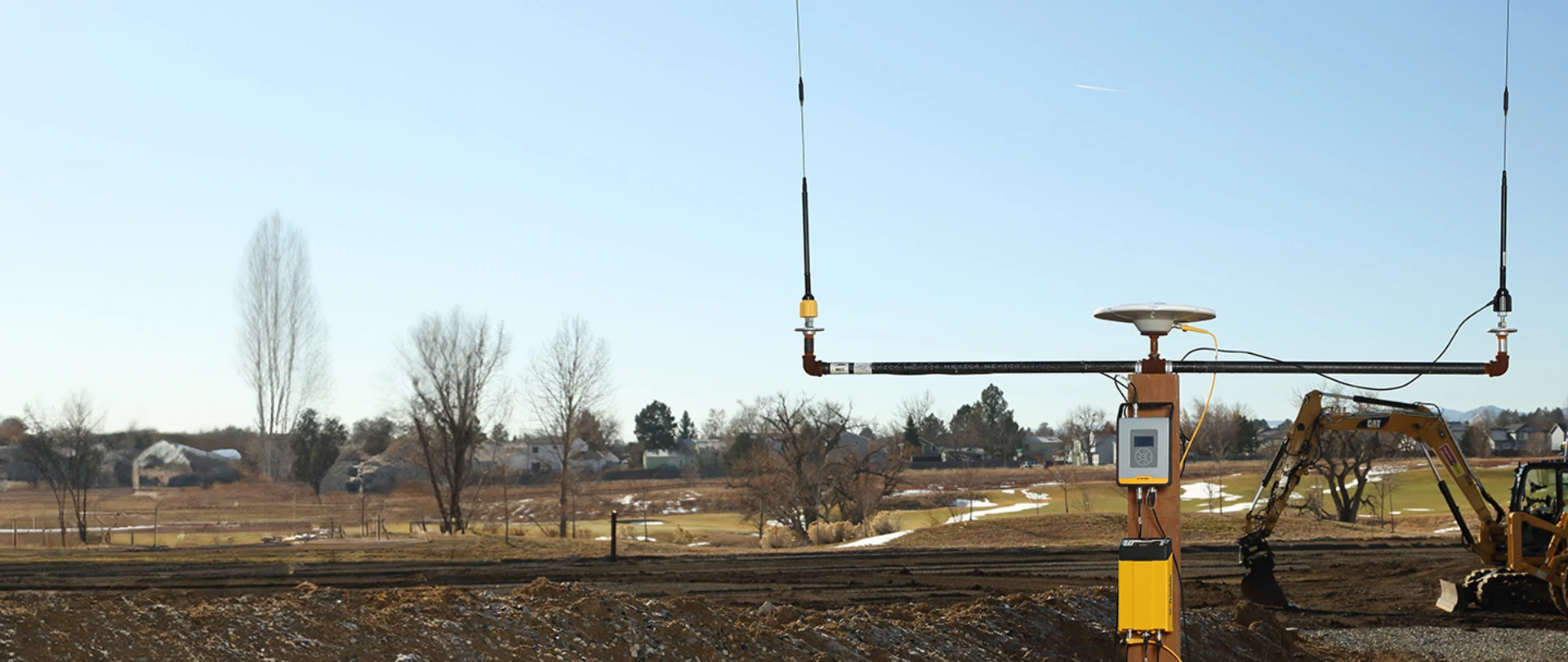 Trimble TDL450B Radio and R750 GNSS Modular receiver with construction site in the background