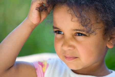 Young girl scratching itchy eczema on her head