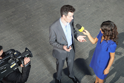 Television reporter interviewing man