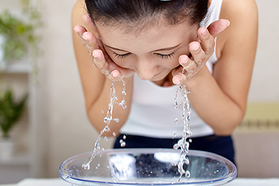 Woman rinsing face with water