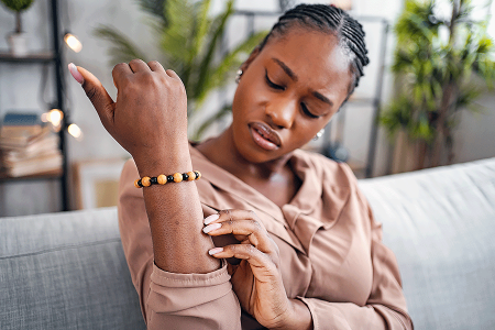 Women looking at dark spots on her arm that appeared when pityriasis rosea rash cleared