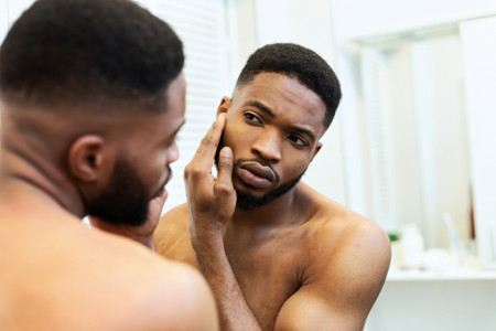 African american man looking in mirror