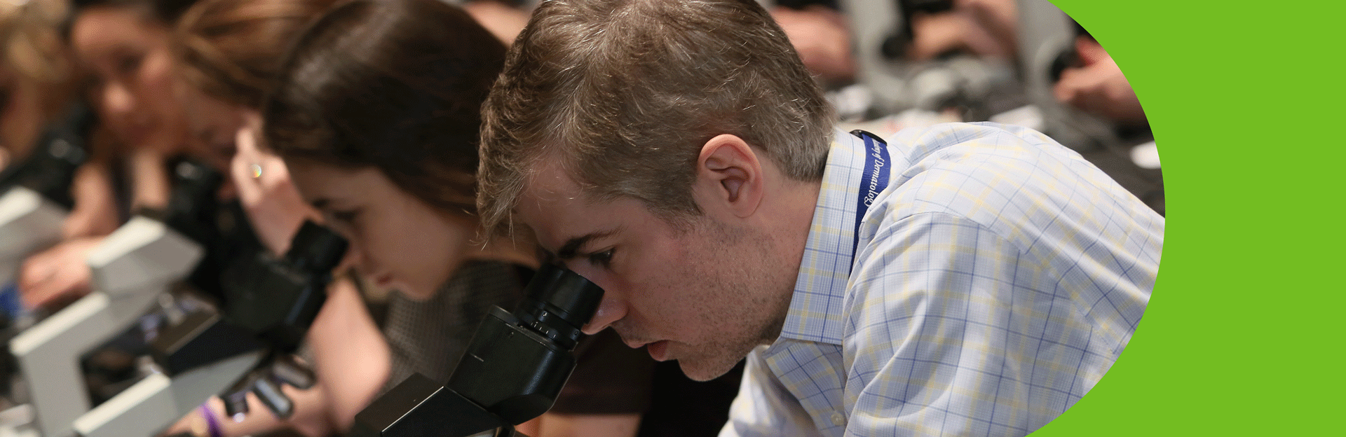 Young dermatologists looking into microscopes