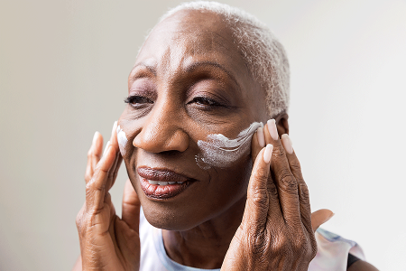Patient with cutaneous T-cell lymphoma applying a moisturizing cream to her face