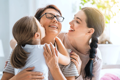 A girl, her mother, and grandmother enjoying sunny morning at home.