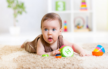 Baby on rug with toys