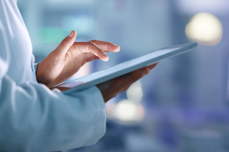 Image of a physician holding a tablet, to illustrate essential health IT solutions to improve physician efficiency