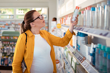 Pregnant person shopping for skin care products in drugstore