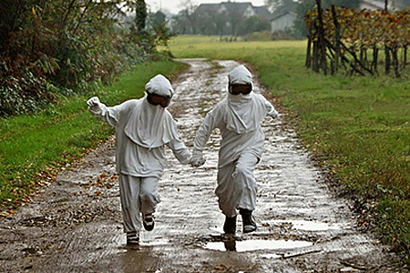 Children playing outside covered with protective clothing from the sun