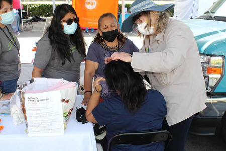 Susan Boiko, MD, FAAD screens a participant while VCC staff look on