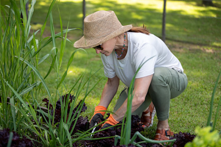 Woman who takes blood pressure medication protects her skin from the sun while working in her garden.