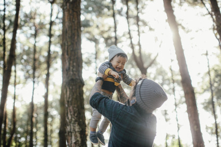 father lifting son in air