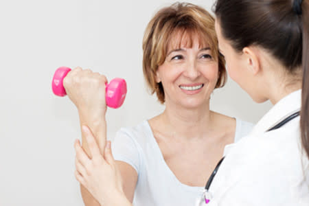 Patient with doctor doing physical therapy by lifting a small hand weight