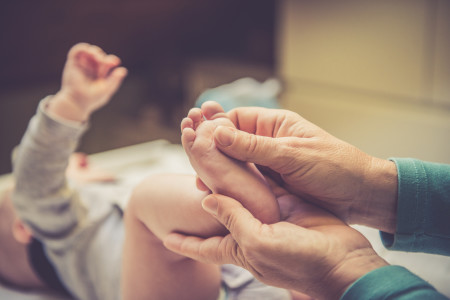 Parent massaging baby’s feet
