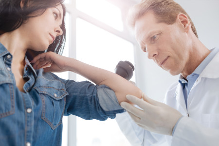 doctor examining woman's arm
