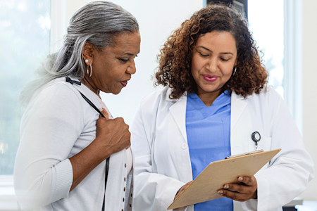 Dermatologist discussing hair loss treatment plan with patient. 