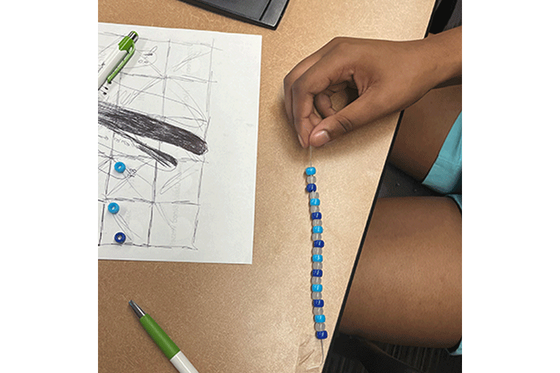 Girls’ STEM Institute making bracelets with UV-sensitive beads.