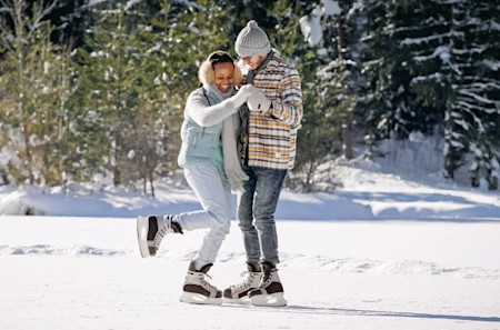 Young couple ice skating on frozen lake