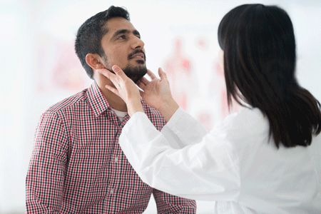 Close-up of man getting lymph nodes in his neck checked by a doctor